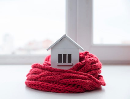 Maison avec bonnet et une echarpe sur le toit 